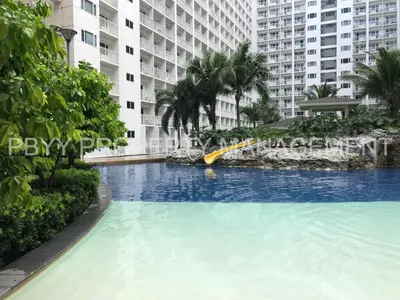 a large swimming pool in front of a large building at Shore Residences, Mall Of Asia Complex Stays by PBYY in Manila