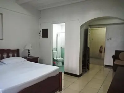 a bedroom with a bed and a bathroom at Casa Micarosa Hotel in Manila