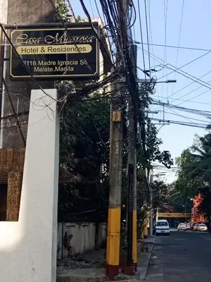 a sign for a hotel and restaurant on a street at Casa Micarosa Hotel in Manila