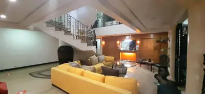 a living room with a yellow couch and a table at Casa Micarosa Hotel in Manila