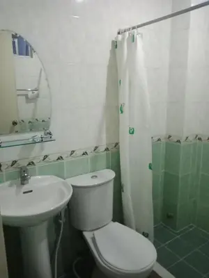 a bathroom with a toilet and a sink and a mirror at Casa Micarosa Hotel in Manila