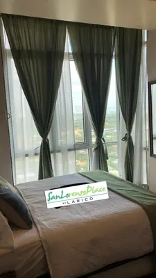 a bed with a sign on it in front of a window at SAN LORENZO PLACE 2BR 29-E by LARICO in Manila