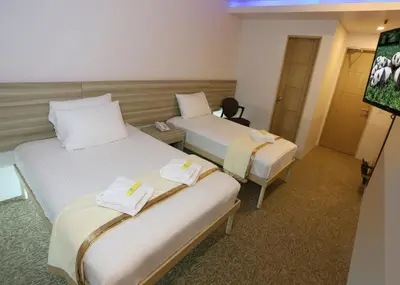 a hotel room with two beds and a tv at 1010 Hotel in Manila