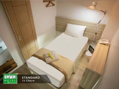 a small bed in a small room with a lamp at 1010 Hotel in Manila