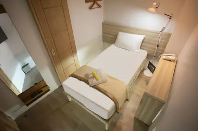 a small room with two beds and a mirror at 1010 Hotel in Manila