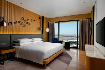 a hotel room with a bed and a large window at Sheraton Manila Hotel at Newport World Resorts in Manila