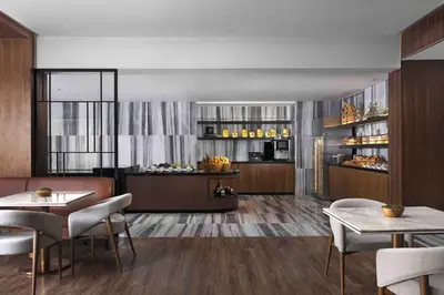 a dining room with tables and chairs and a kitchen at Sheraton Manila Hotel at Newport World Resorts in Manila