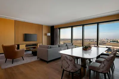 a living room with a table and chairs and a television at Sheraton Manila Hotel at Newport World Resorts in Manila