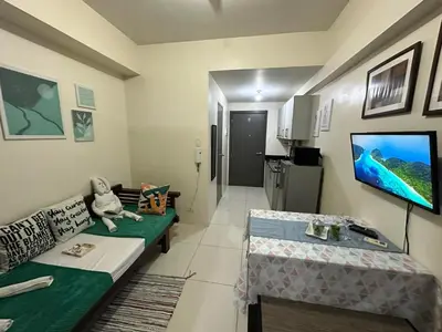 a living room with a couch and a tv at Green Residences Stays by PBYY in Manila