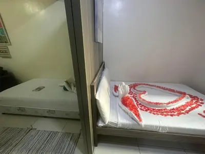 a room with two beds with a red and white blanket at Green Residences Stays by PBYY in Manila