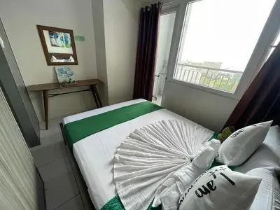 a small bedroom with a bed with a window at Green Residences Stays by PBYY in Manila