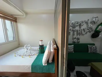 a bedroom with a bed with a happy birthday sign at Green Residences Stays by PBYY in Manila
