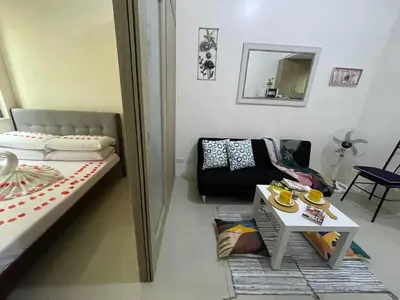 a living room with a couch and a table at Shore Residences, Mall Of Asia Complex Stayction by PBYY in Manila