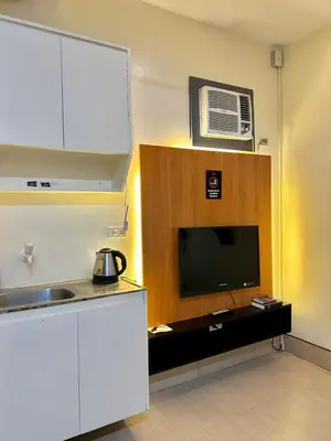 a kitchen with a sink and a tv in a room at Selah Lofts Hotel in Manila