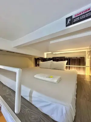 a bedroom with a large white bed in a room at Selah Lofts Hotel in Manila