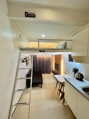 a small room with a loft bed and a table at Selah Lofts Hotel in Manila