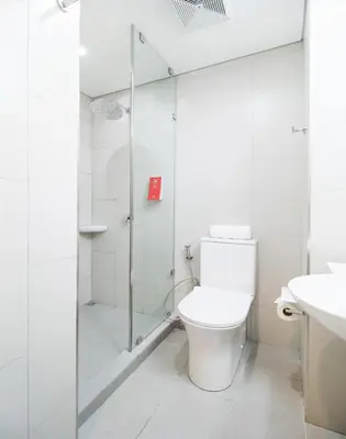 a white bathroom with a toilet and a shower at Red Planet BGC The Fort in Manila