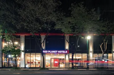 a red planetutics store at night with trees in front at Red Planet BGC The Fort in Manila
