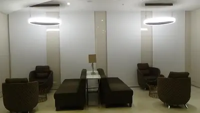 a waiting room with chairs and a table and lights at 1BR Grace Residences w/ Internet- near BGC/McKinley in Manila