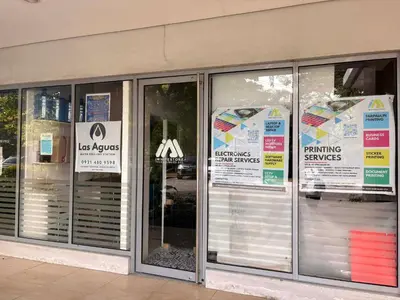 a store with signs in the windows of a building at Cozy Staycation at Eastbay Residences in Manila