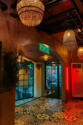 a restaurant lobby with chandeliers and a sign on the wall at CONNECTOR Hostel in Manila