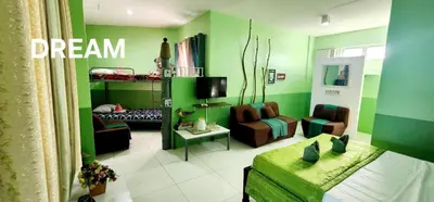 a living room with green walls and a couch and chair at ROCCA Del GARDA Residences in Binangonan