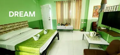 a green room with a bed and a tv at ROCCA Del GARDA Residences in Binangonan