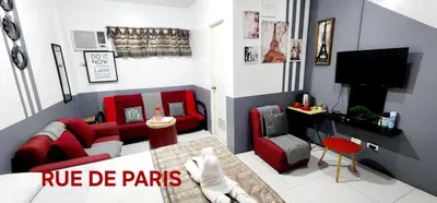 a living room with a red couch and a tv at ROCCA Del GARDA Residences in Binangonan