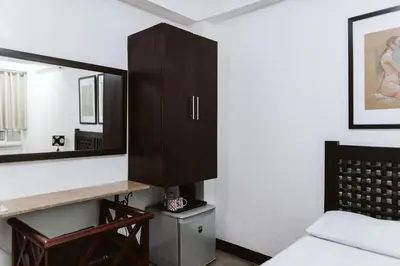 a bedroom with a mirror and a bed at San Agustin Residences in Manila