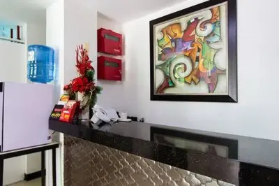 a living room with a fireplace and a painting on the wall at San Agustin Residences in Manila