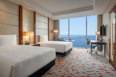 a hotel room with two beds and a large window at Solaire Resort Entertainment City in Manila