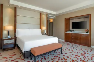 a hotel room with a bed and a television at Solaire Resort Entertainment City in Manila