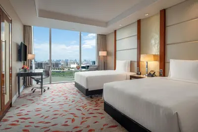 a hotel room with two beds and a large window at Solaire Resort Entertainment City in Manila