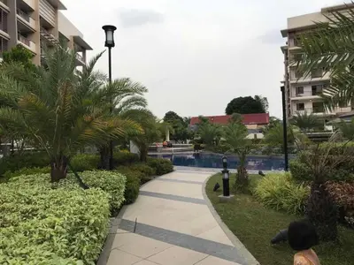 a walkway with palm trees and a swimming pool at MaRoy Suites at Asteria Residences (Near NAIA with free Parking+Fiber Internet) in Manila