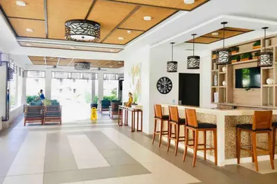 a living room with a kitchen and a bar with chairs at MaRoy Suites at Asteria Residences (Near NAIA with free Parking+Fiber Internet) in Manila