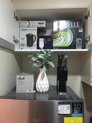 a shelf with a vase on top of a machine at Modern and Cozy Studio near Airport Terminal 3 in Manila
