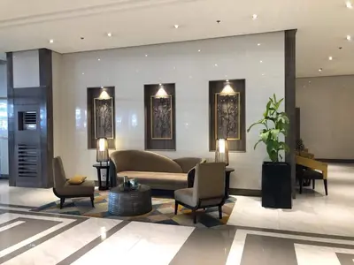 a lobby with a couch and chairs in a building at Modern and Cozy Studio near Airport Terminal 3 in Manila
