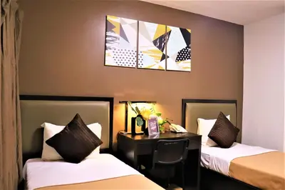 a hotel room with two beds and a desk at The Studio 18 Residences in Manila