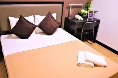 a bedroom with a bed with two towels on it at The Studio 18 Residences in Manila