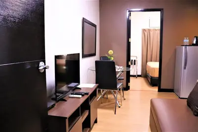 a room with a desk with a computer and a bed at The Studio 18 Residences in Manila