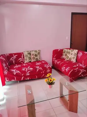 a living room with a red couch and a glass table at Cubao ManhattanHeights Unit 7EF Tower B, 1BR in Manila