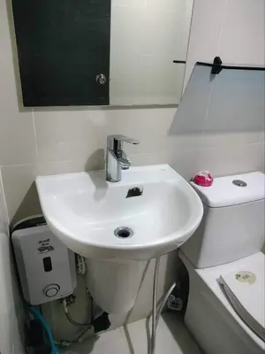 a bathroom with a white sink and a toilet at Cubao ManhattanHeights Unit 7EF Tower B, 1BR in Manila