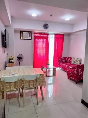 a living room with a table and red curtains at Cubao ManhattanHeights Unit 7EF Tower B, 1BR in Manila
