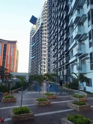 a large apartment building with a courtyard in front of it at Cubao ManhattanHeights Unit 7EF Tower B, 1BR in Manila
