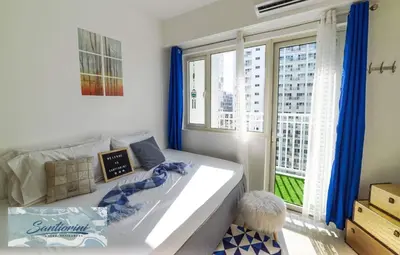 a bedroom with a large bed and a large window at Santiorini at Shore Residences in Manila