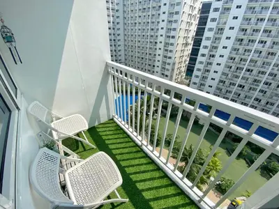 two chairs on a balcony with a view of a building at Santiorini at Shore Residences in Manila