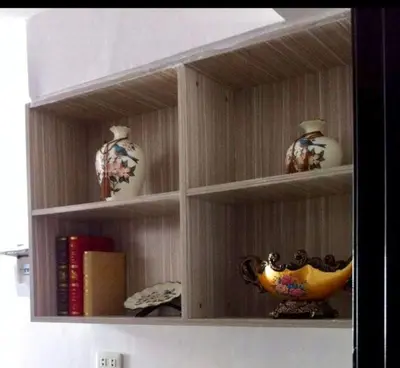 a book shelf with vases and a bowl on it at Estien’s Cozy Condotel to Stay in Imus