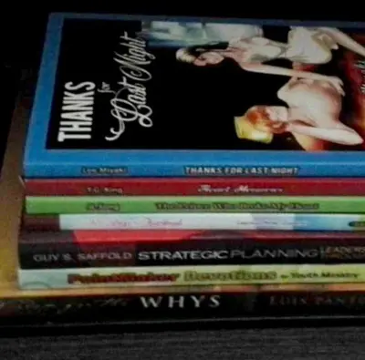 four books stacked on top of each other on a shelf at Estien’s Cozy Condotel to Stay in Imus
