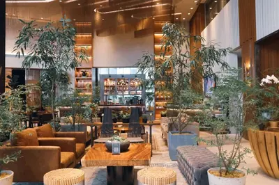 a lobby with tables and potted plants at Brittany Hotel BGC in Manila