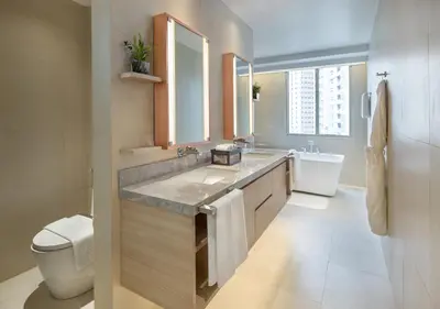 a bathroom with a sink and a toilet at Brittany Hotel BGC in Manila